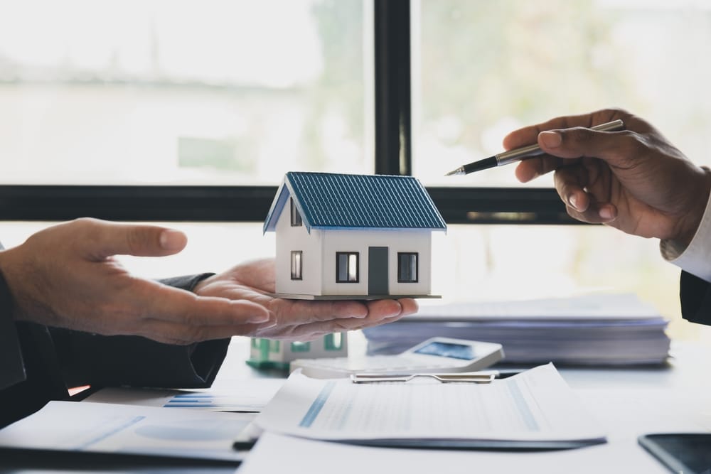 Real,Estate,Agent,Home,Sales,Broker,Holding,Calculator,And,Pointing