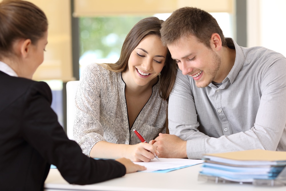 Happy,Couple,Signing,A,Contract,Together,At,Office