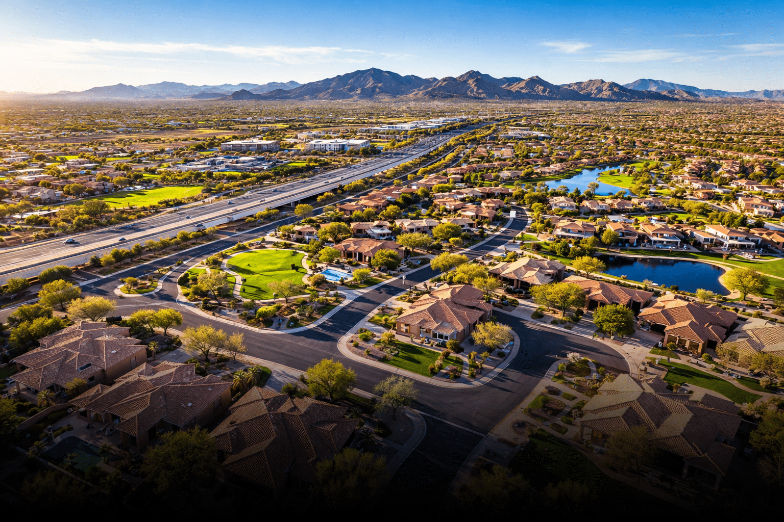 Glendale AZ real estate Arrowhead area aerial view of master-planned community with terracotta rooftops and desert mountains — West USA Realty